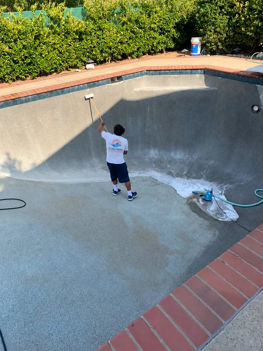Pool interior being rinsed by a technician