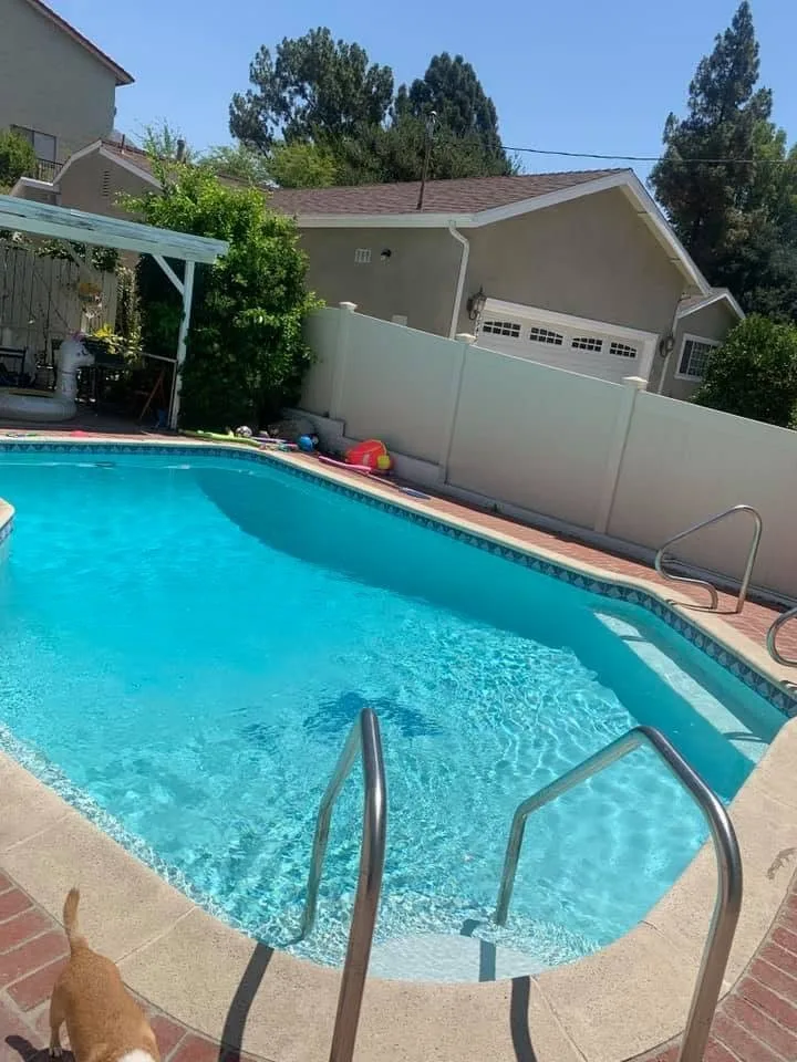Clear backyard pool beside a house