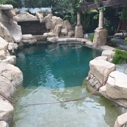 Rock-lined pool with blue-green water and a raised waterfall