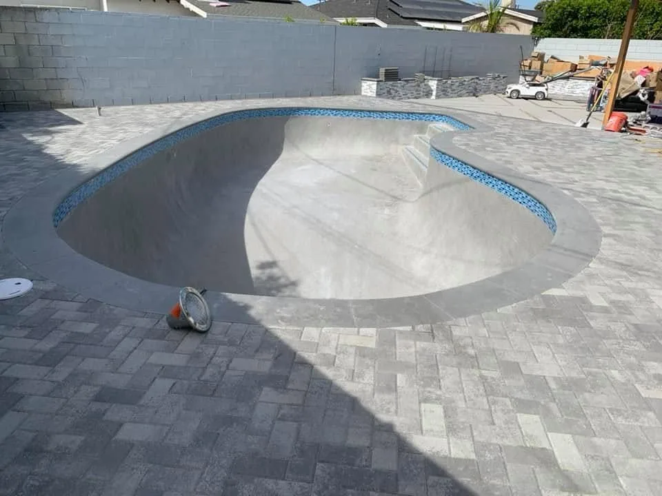 Drained pool with a plaster interior and brick pavers