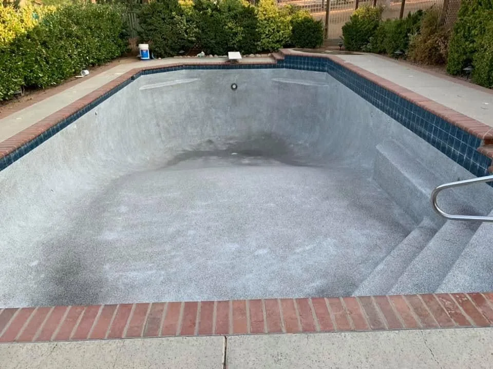 Drained pool interior with brick coping