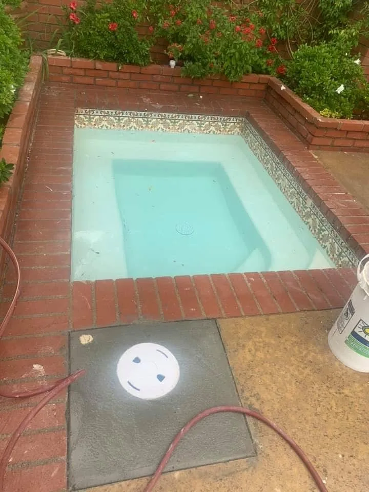 Drained spa with waterline tile and brick surround
