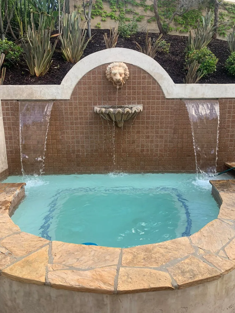 Spa with a fountain water feature and stone surround